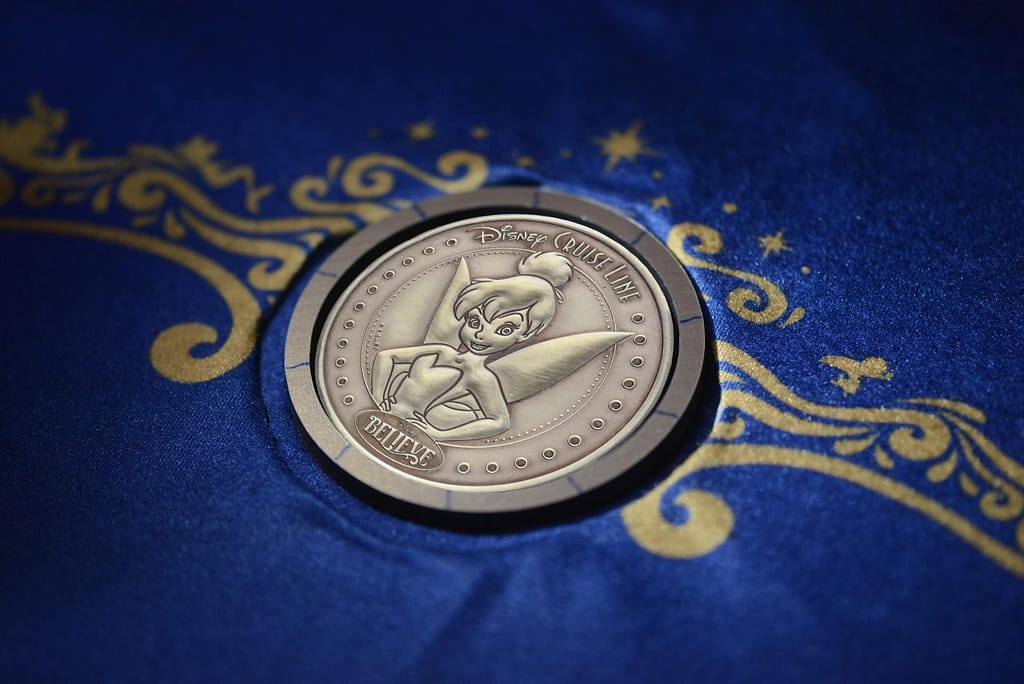 A custom minted coin depicting a portrait of Tinker Bell was placed beneath Disney Believe's keel