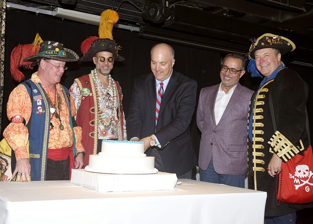Carnival Chief Communications Officer Chris Chiames and Port Tampa Bay Executive Vice President Raul Alfonso join local Gasparilla pirates to cut 30th anniversary cake