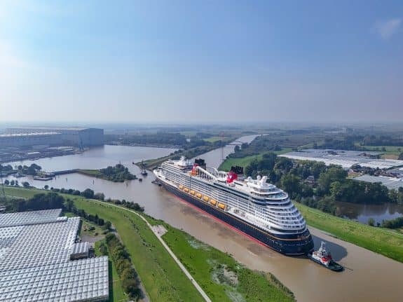 Disney Treasure being guided by Tug Boat down the Ems River