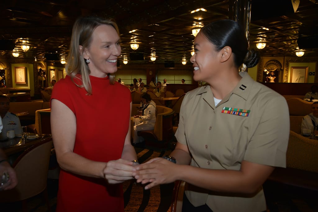 Navy veteran Vera Lannek, Vice President of Strategic Sourcing for Carnival Corporation shares a commemorative coin with a service member